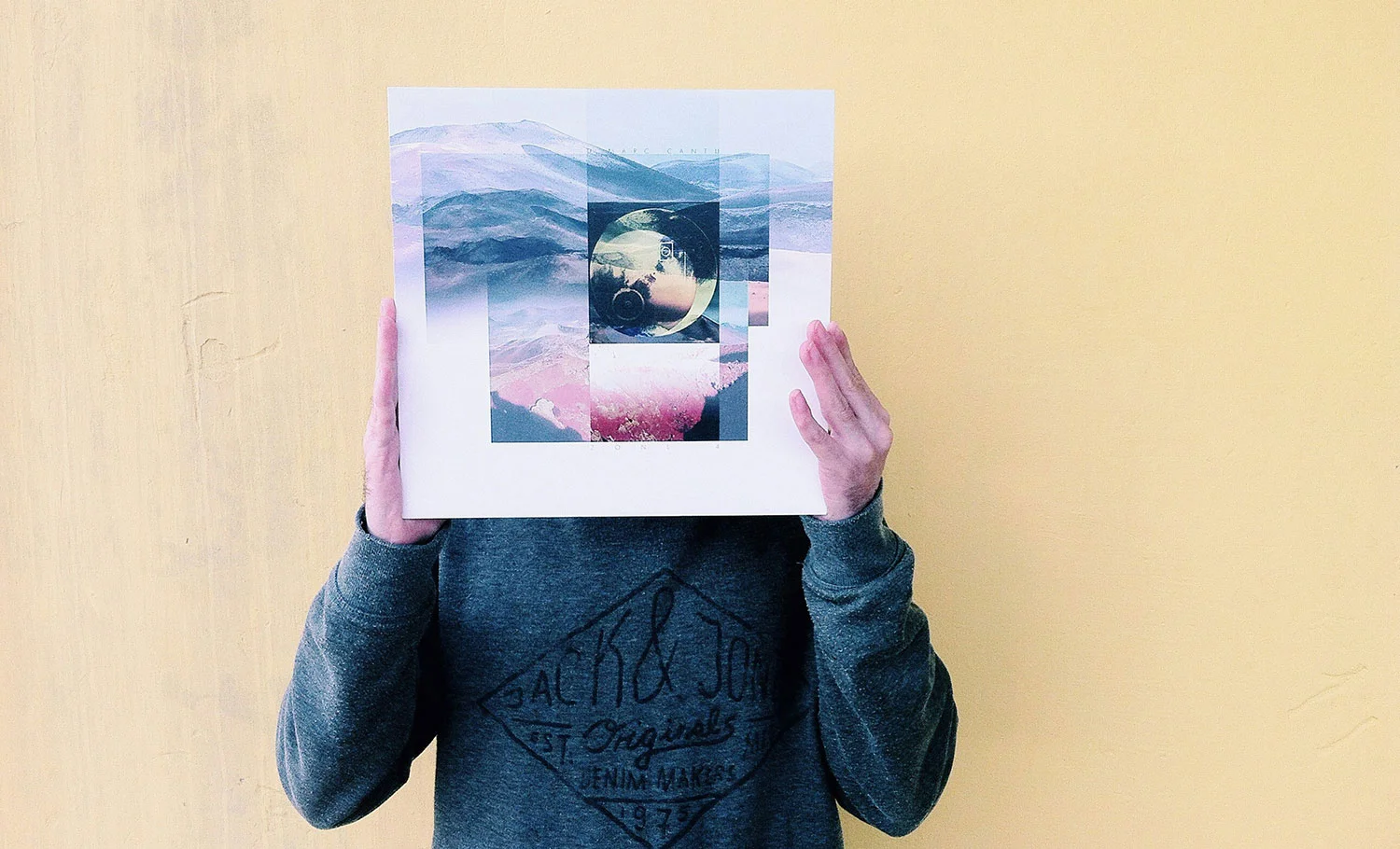 Persona sosteniendo un vinilo sobre su rostro