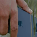 Mano sosteniendo un celular en la naturaleza