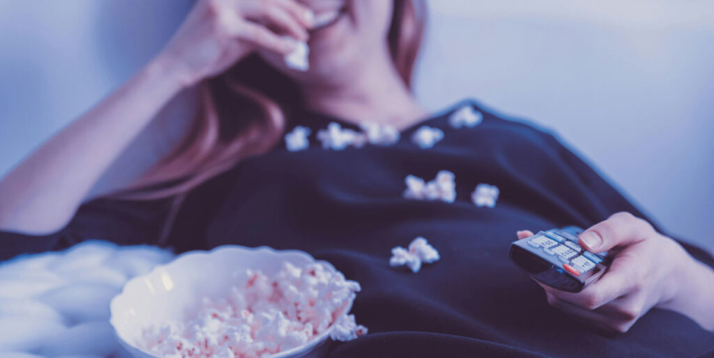 Mujer comiendo palomitas mientras mira una película