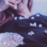 Mujer comiendo palomitas mientras mira una película